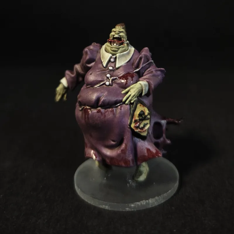 Un zombie obèse en robe violette à col blanc, sur un socle transparent.